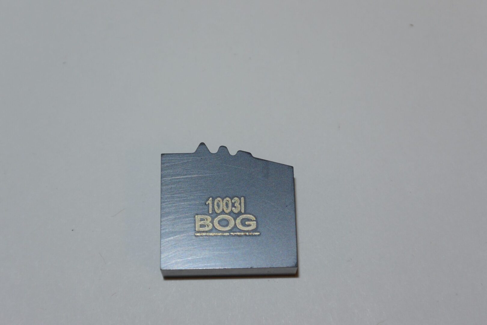 A metal object with the words " 1 0 6 3 i 8 0 g ".