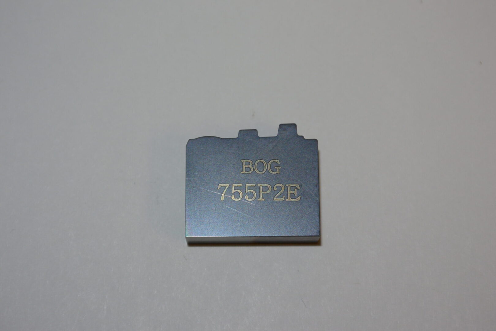 A small piece of metal with the word " bug 7 5 5 9 2 b ".